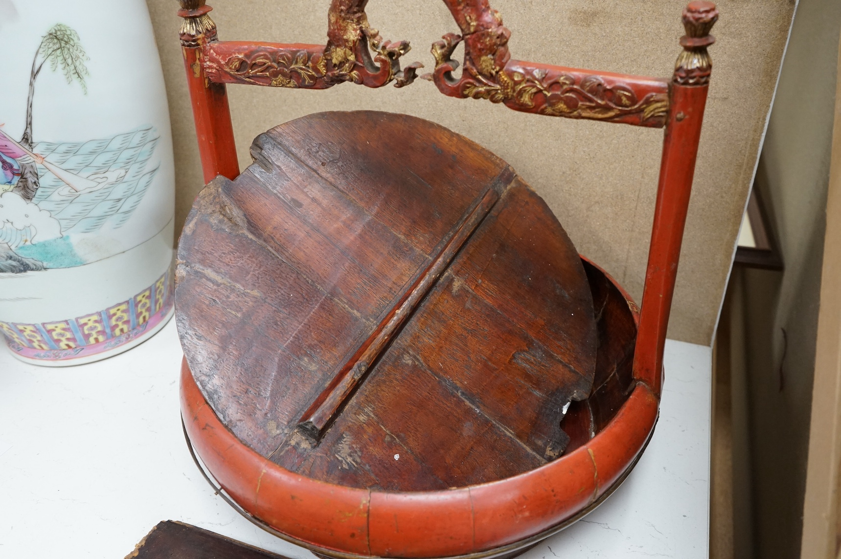 A Chinese red lacquered picnic box and figurative carved gilt painted panel. Picnic box 37cm diameter. Condition - fair